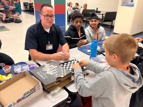 Lieutenant Greg Strehle plays games with middle school students during lunch period.