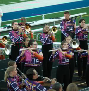 students playing instruments on football field