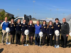students posing with shovels and hard hats
